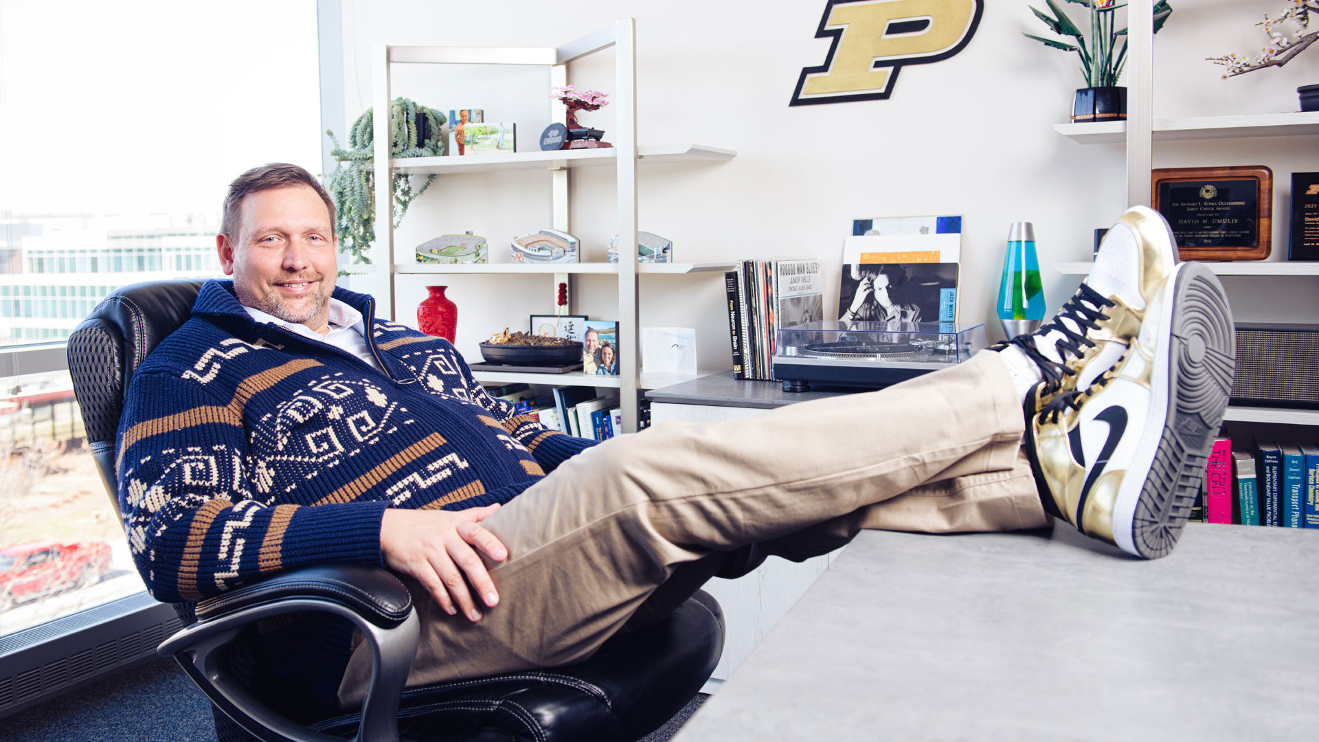 David Umulis’ informal nature extends to his preferred style of dress, including Mr. Rogers-style sweaters and Air Jordan 1 sneakers in Purdue black and gold. (Photo by Rebecca McElhoe/Purdue Marketing and Communications)