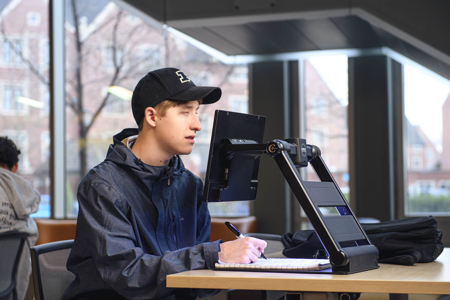 David reads his homework with a magnifying system that has an adjustable monitor.