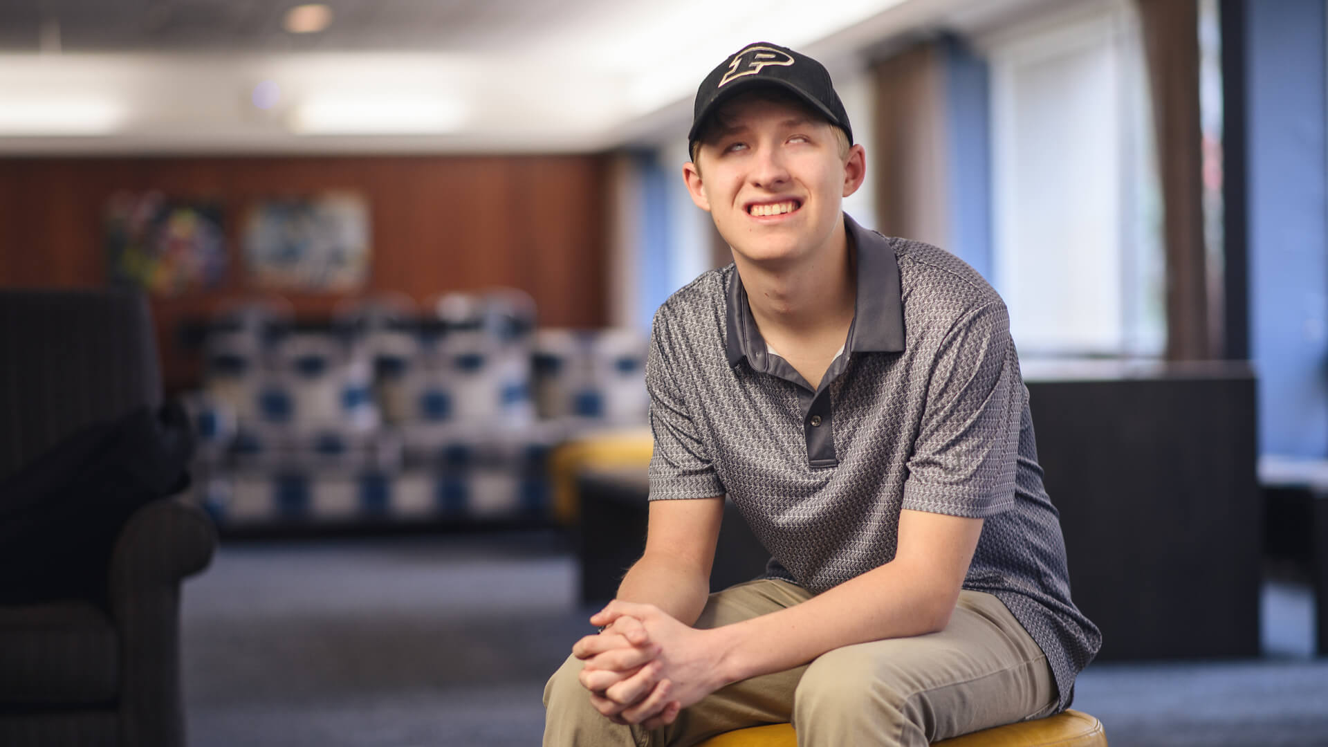 David poses at Krach Leadership Center, wearing a Purdue baseball hat and polo shirt