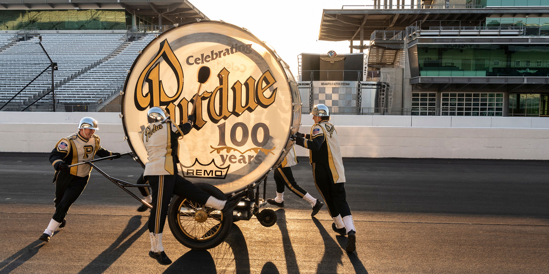 The Big Bass Drum crew — celebrating 100 years of the drum in 2022 — perform on the track of the Indianapolis Motor Speedway.