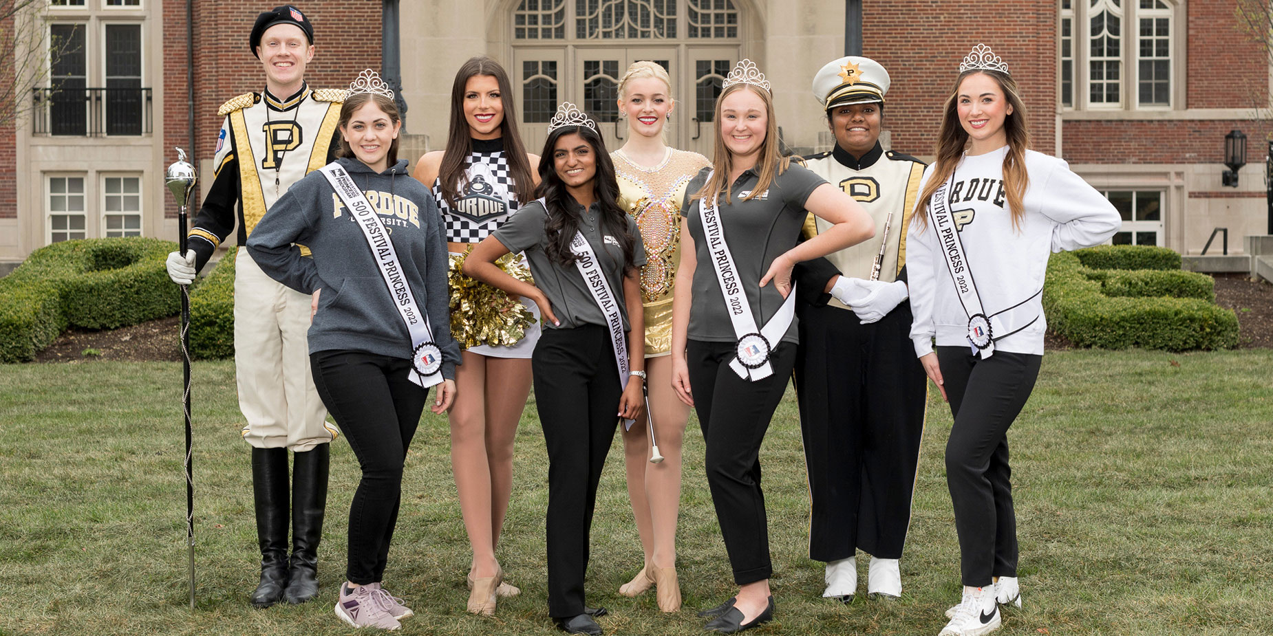 Members of the Purdue “All-American” Marching Band and four of the 500 Festival Princesses representing the University at the Indianapolis 500 stand in front of the Purdue Memorial Union.