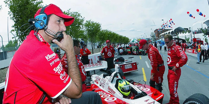 Bill Pappas stands with his foot on Bruno Junqueria’s vehicle before the start of the 2002 Grand Prix of Long Beach in California. 