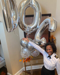 Krystal Dabon poses with a set of balloons commemorating that she completed a Doctor of Nursing Practice degree through Purdue University Global.
