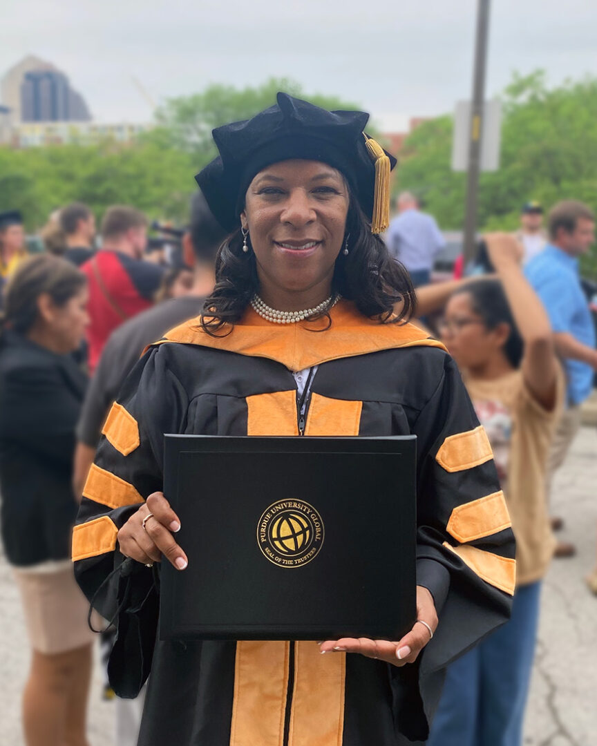 Krystal Dabon holds her Doctor of Nursing Practice diploma at Purdue University Global’s spring 2022 commencement.