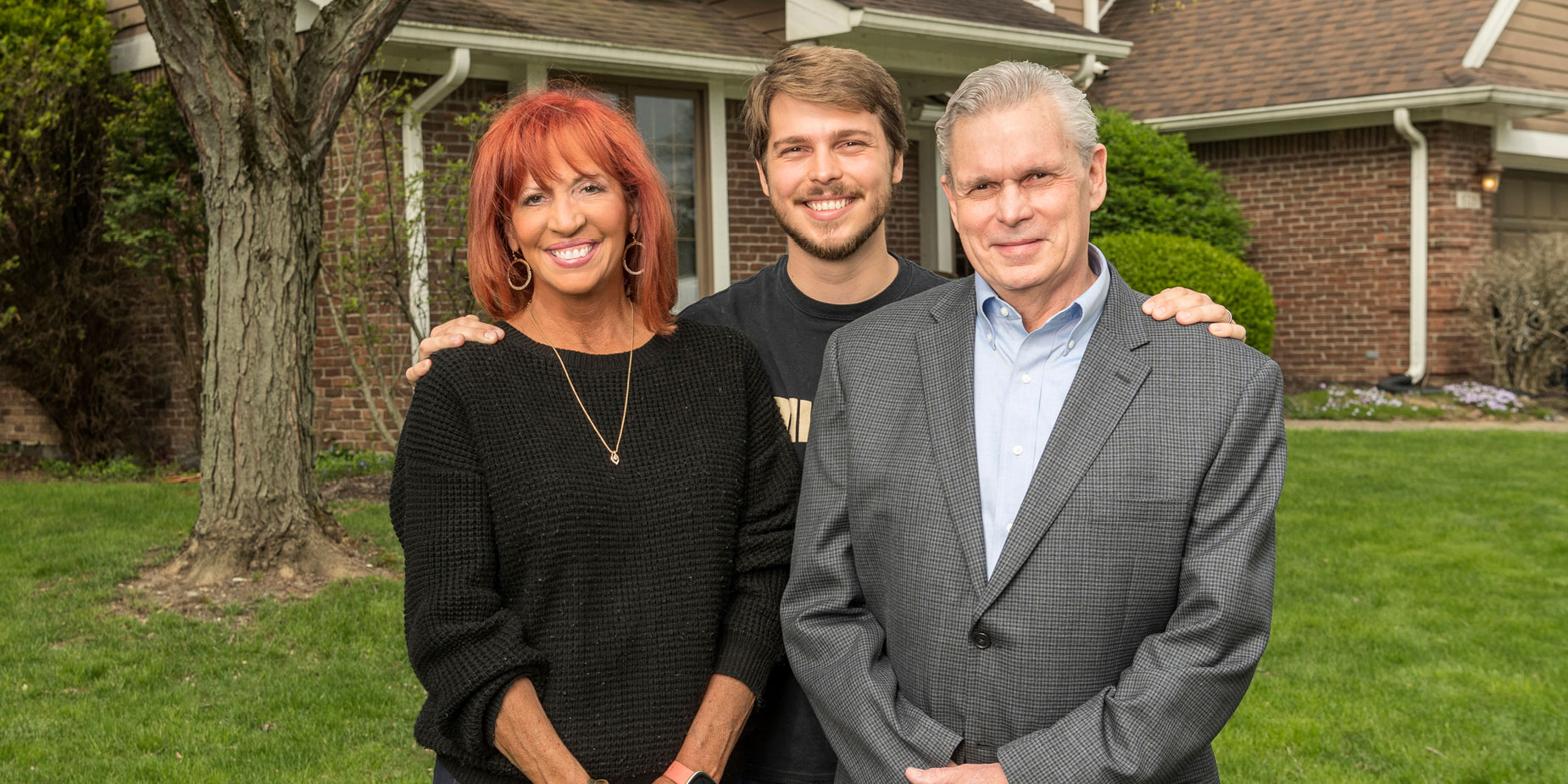 Linda, Logan and Keith Noster pose for a photo in front of their home in Indianapolis.