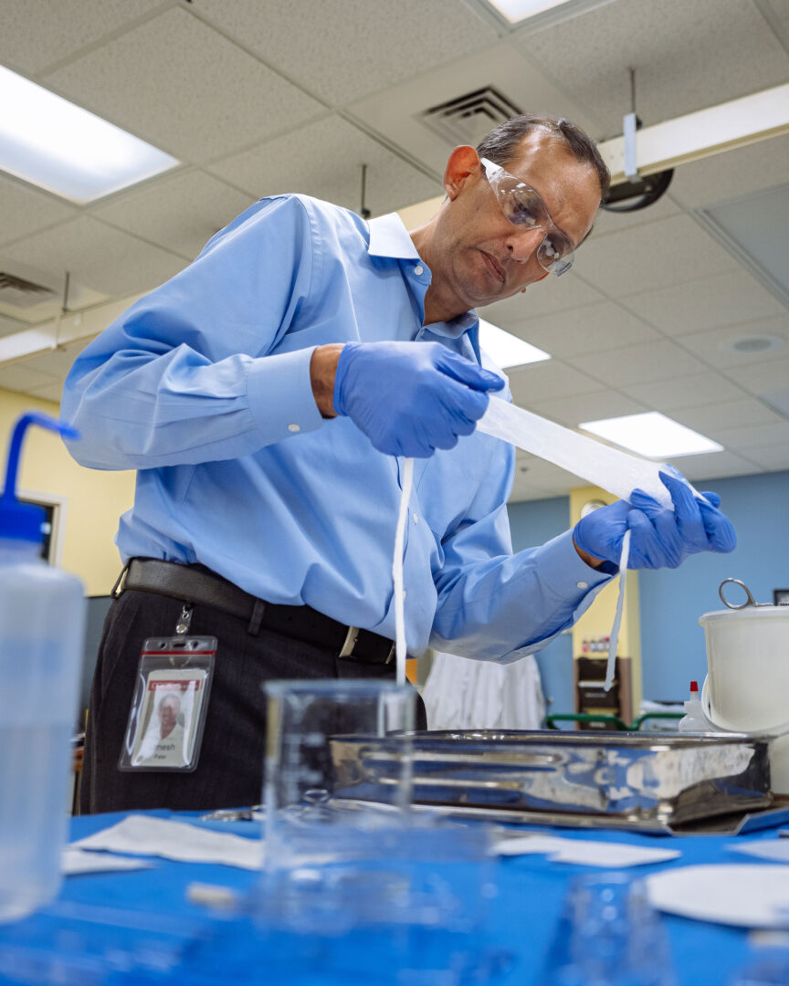 Cook Biotech President Umesh Patel examines a sample of SIS material at the company’s headquarters in the Purdue Research Park.