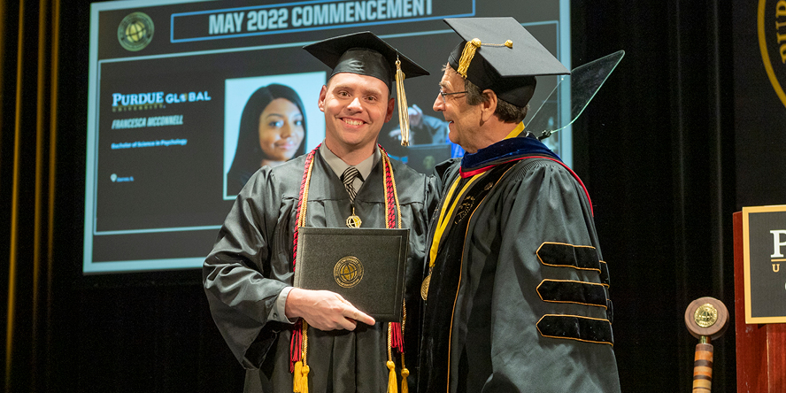 Justin Marvin poses with Purdue University Global Chancellor Frank Dooley at commencement.