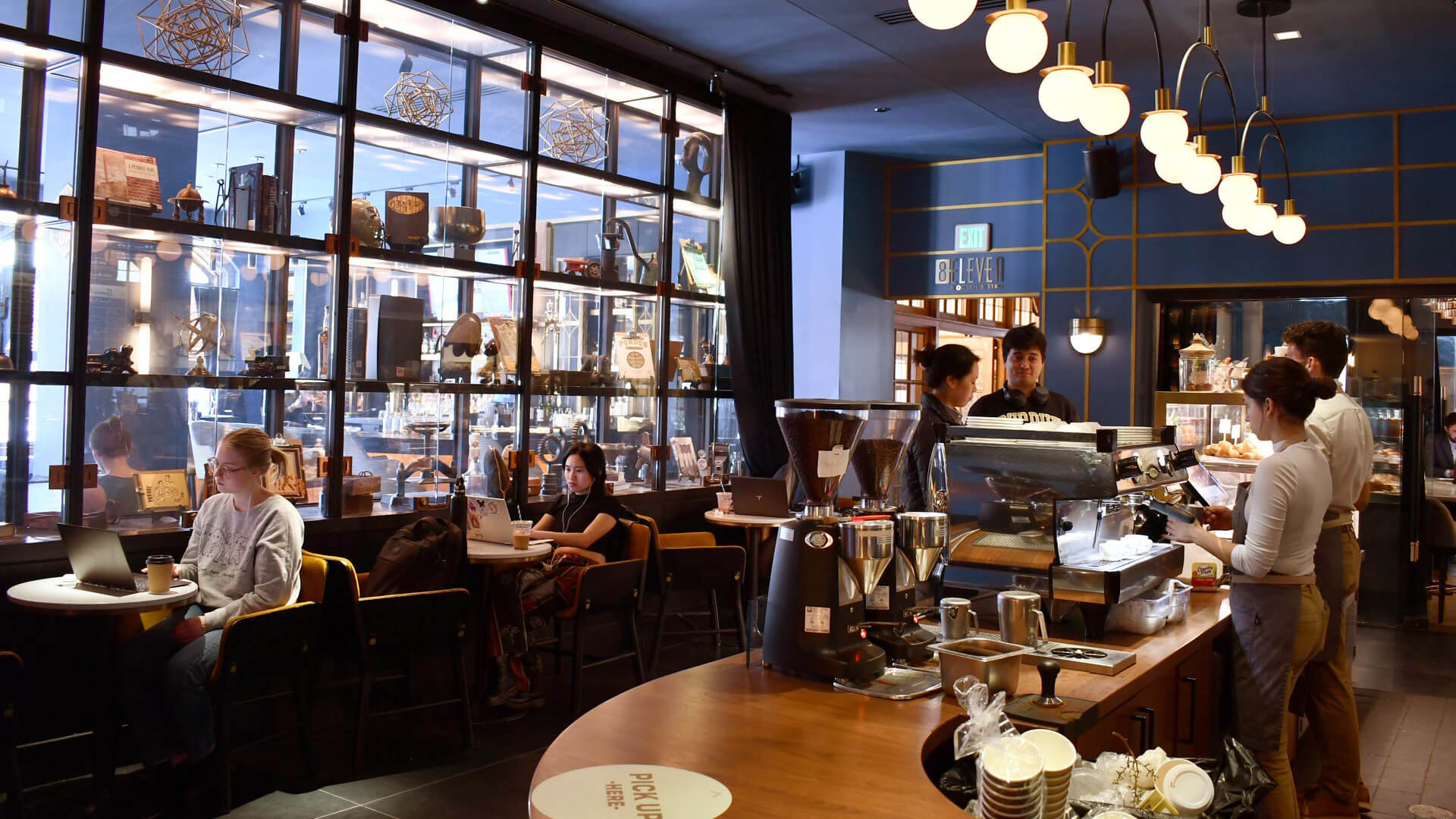 People sitting and ordering coffee in the navy-blue Leaps Coffee shop.