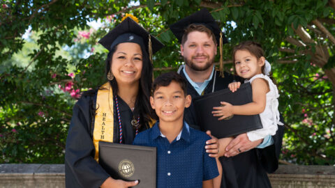 James and Tracy Ly Scott at Purdue Global commencement with children Damien and Jocelyn.