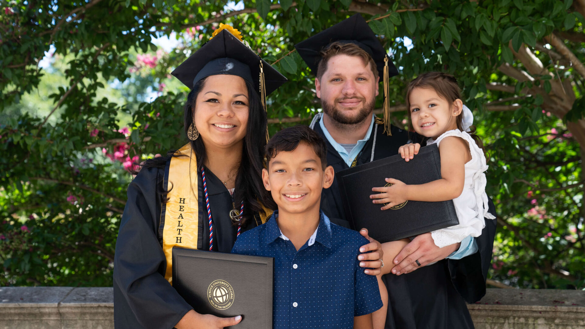 James and Tracy Ly Scott at Purdue Global commencement with children Damien and Jocelyn.