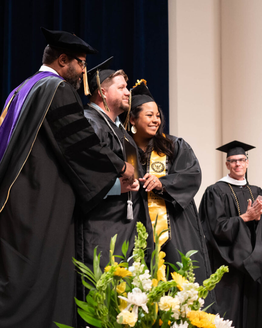 James and Tracy Ly Scott accepting their diplomas together at Purdue Global summer 2022 commencement.