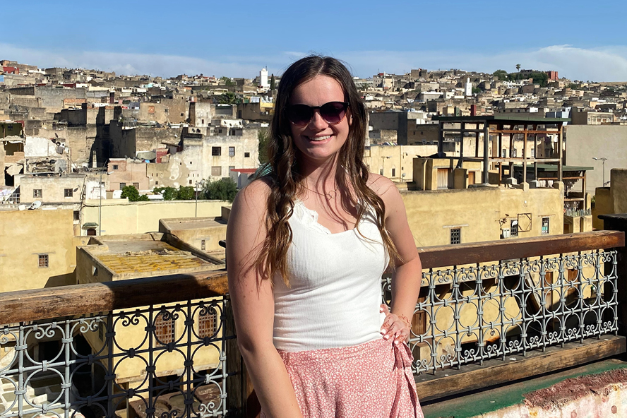 Alexia leans on a fence overlooking the city