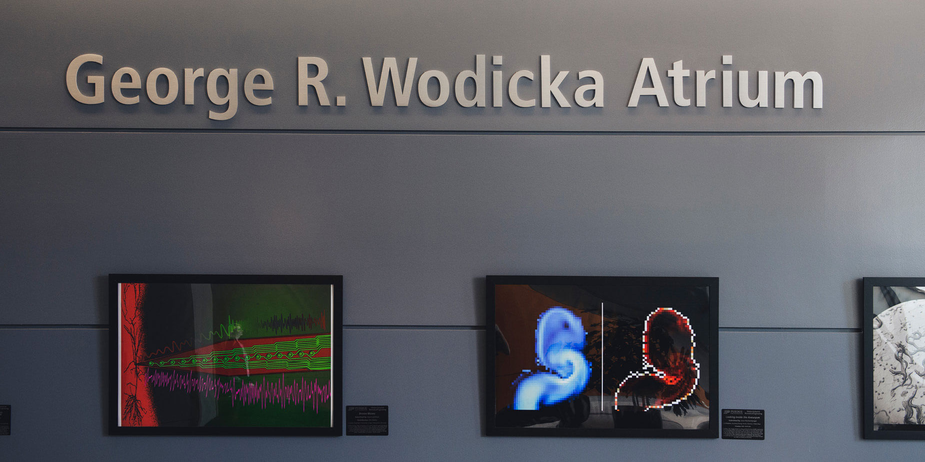 A sign on the first-floor wall in Martin C. Jischke Hall of Biomedical Engineering displays the atrium’s new title, the “George R. Wodicka Atrium.”