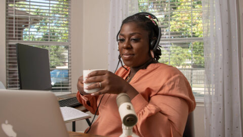 Jacque reviews information on a computer screen while working at home.