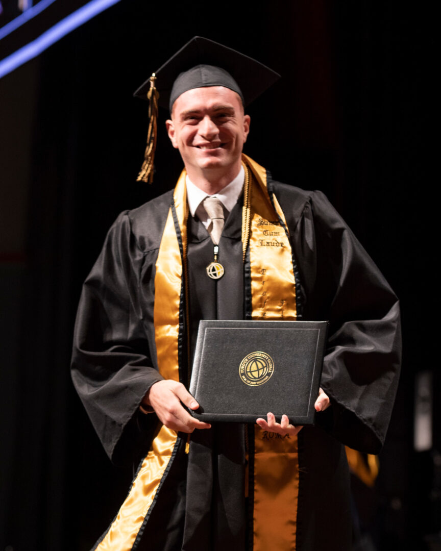 Gabe Giusti poses with his Purdue Global diploma.