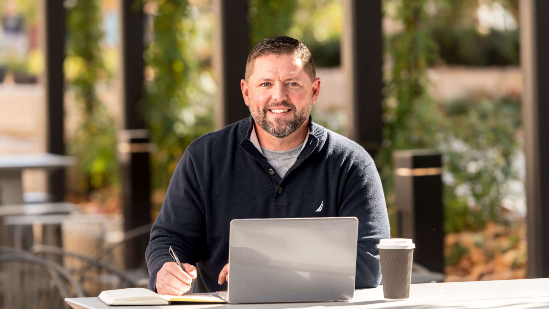 Purdue Global graduate Tony Friesner studying outside.