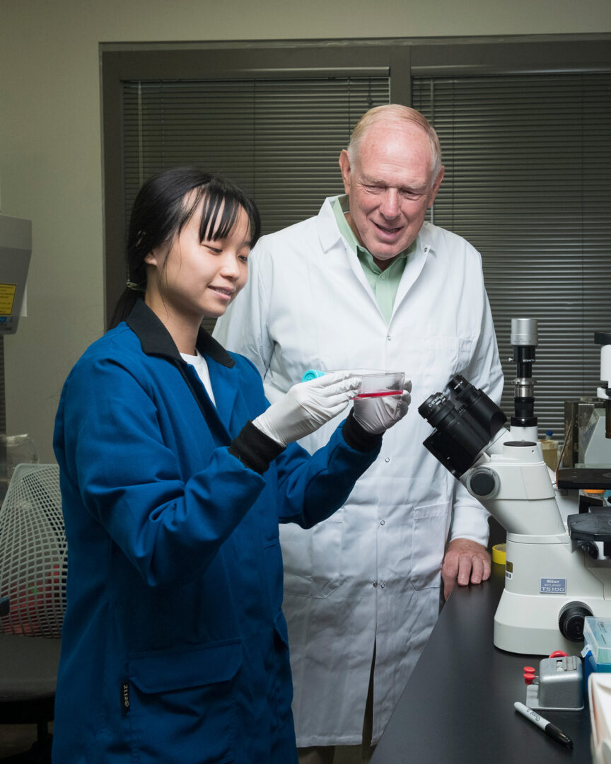 Philip Low collaborates with a researcher in a laboratory.