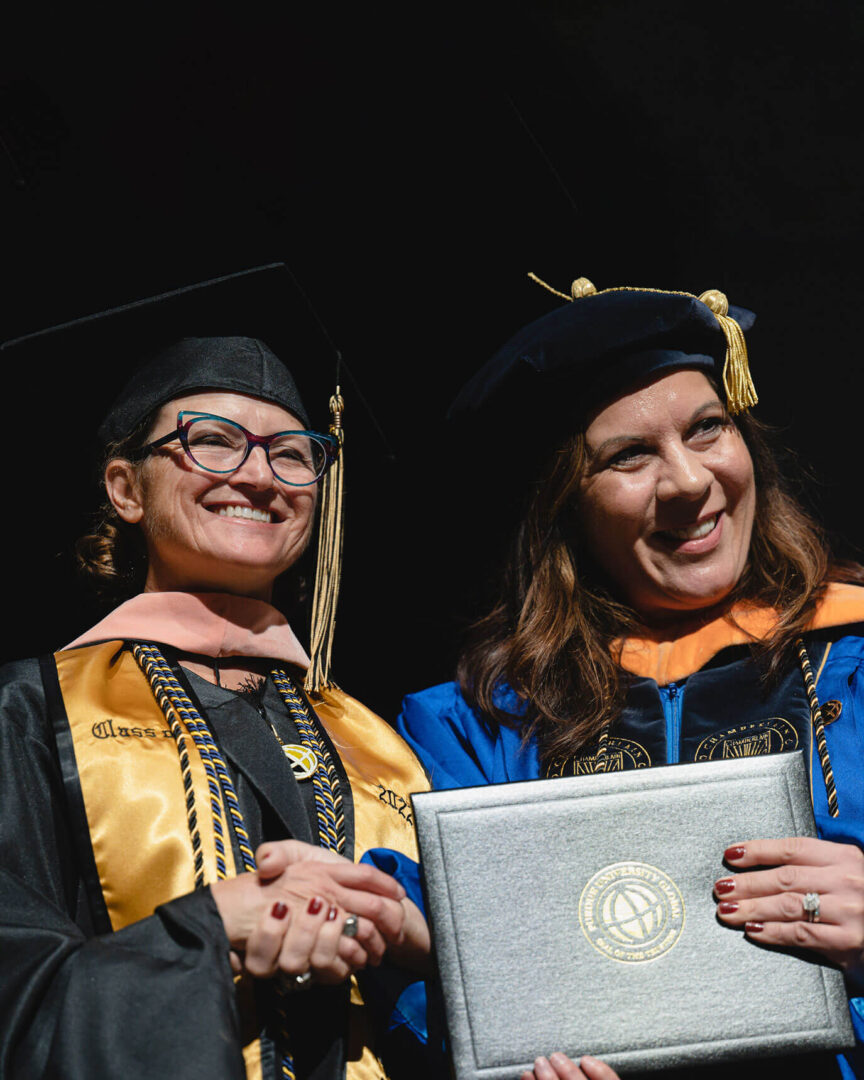 Dean Melissa Burdi shakes hands with a new nursing graduate at Purdue Global’s October 2022 commencement.