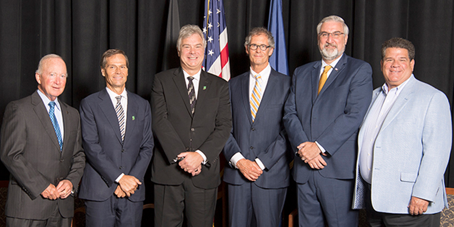 Purdue President Mitch Daniels, Indiana Secretary of Commerce Bradley Chambers, SkyWater Technology president and CEO Thomas Sonderman, West Lafayette Mayor John Dennis, Indiana Gov. Eric Holcomb and Lafayette Mayor Tony Roswarski pose at the event announcing SkyWater will build a semiconductor manufacturing facility at Purdue.