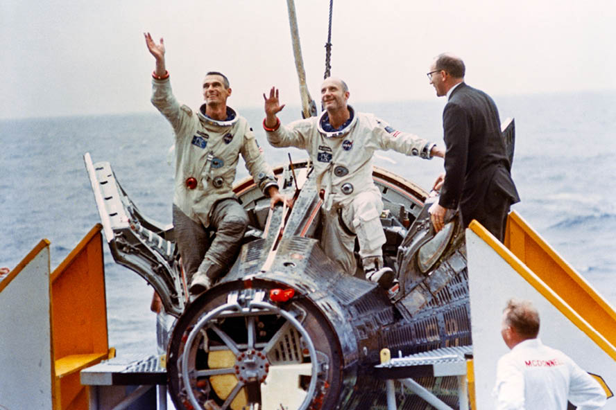 Gemini 9 astronauts Eugene Cernan and Thomas Stafford wave to the crew of the USS Wasp after splashing down in the Atlantic Ocean.