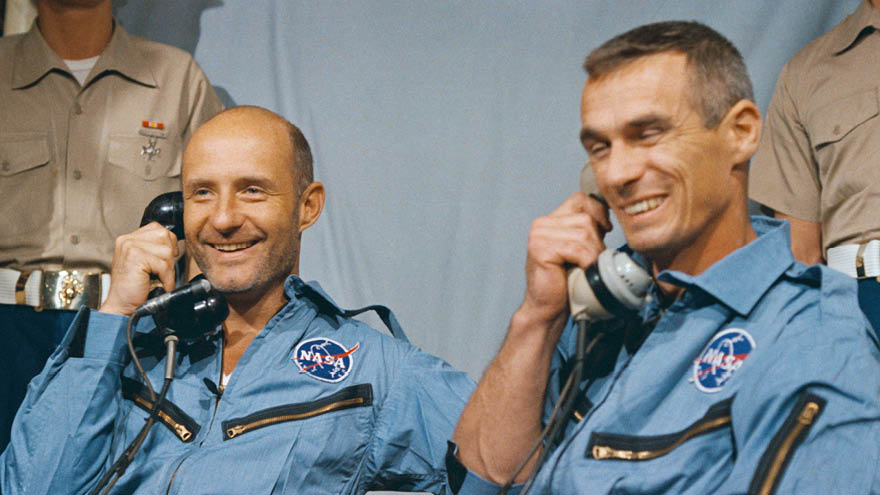 Astronauts Thomas Stafford and Eugene Cernan speak by phone with President Lyndon B. Johnson after splashing down aboard Gemini 9.