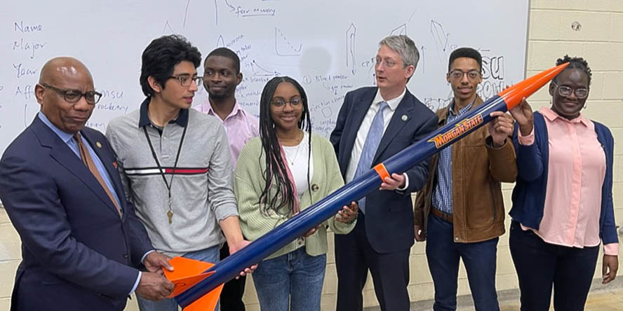 Don-Terry Veal Jr. and the Morgan State Rocketry Team pose with a large rocket.