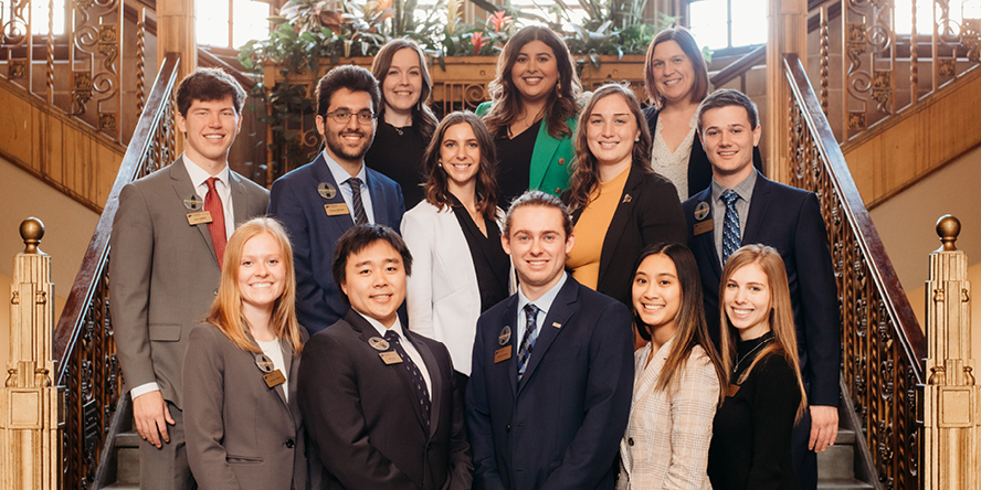 Parsia Bahrami poses on a staircase with other members of Rising Professionals.