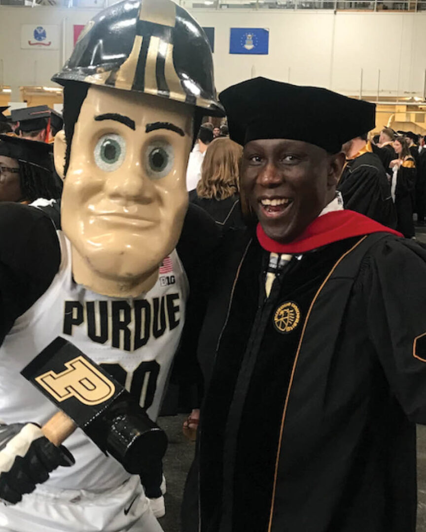 Nixon Opondo and Purdue Pete at the Purdue commencement ceremony.