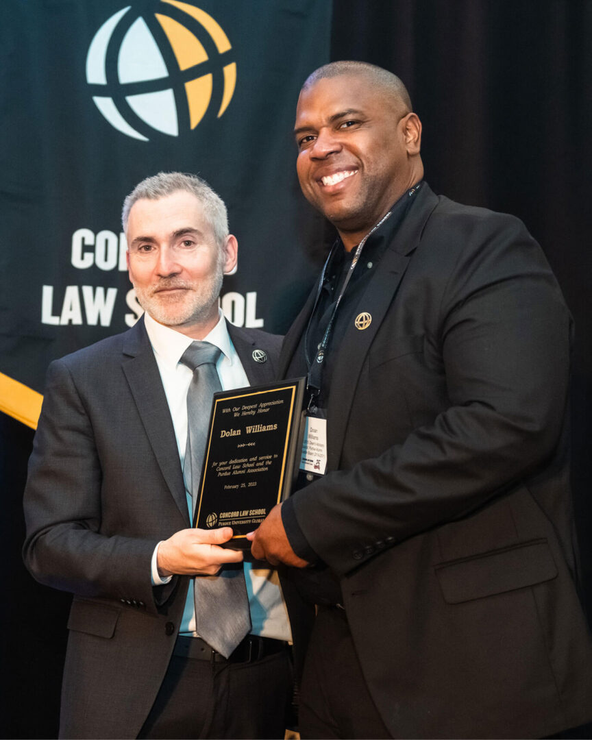 Dolan Williams receives an award from Martin Pritikin, dean of Concord Law School.