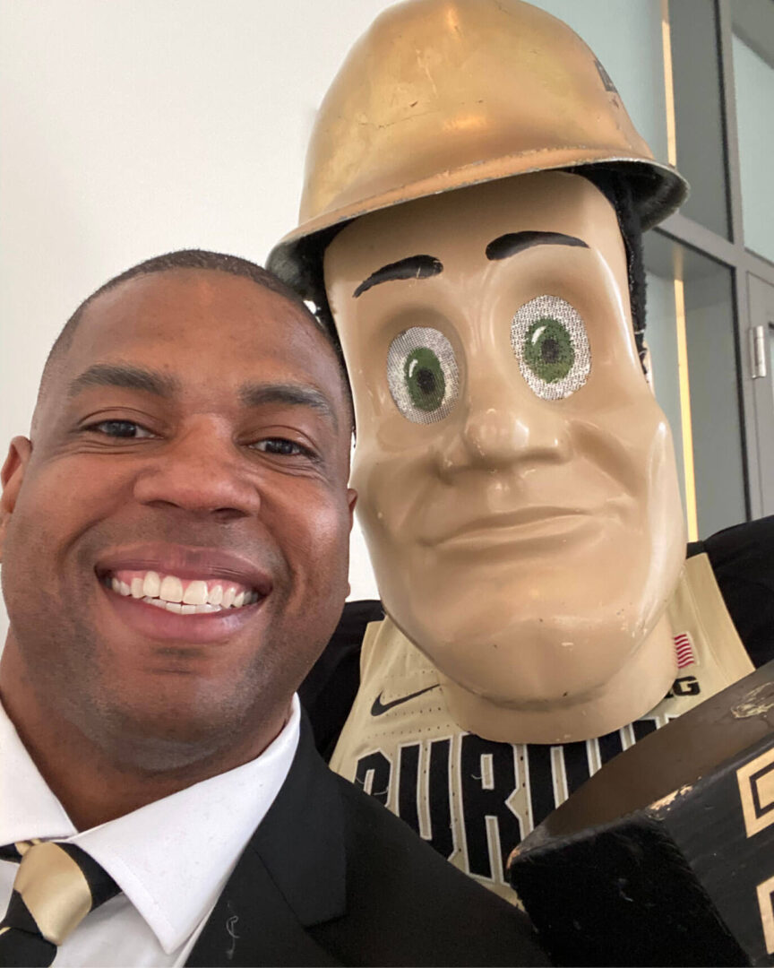 Dolan Williams stands with Purdue Pete after the 2020 Purdue Global commencement.