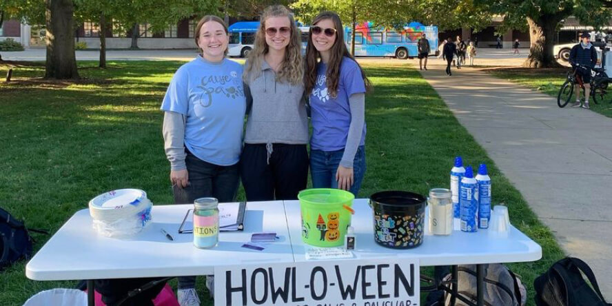 Students pose at A Cause For Paws’ table during orientation