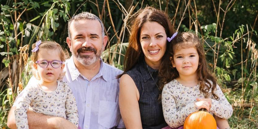 Dr. Michelle Ludwig and her family pose in a pumpkin patch, alongside Dr. Ludwig’s hearing service dog, Pam.