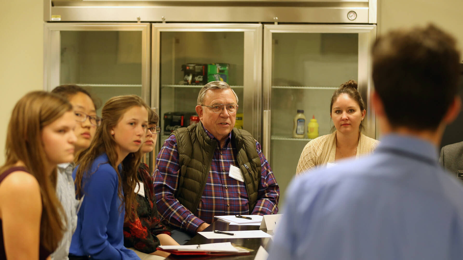 Vic Lechtenberg sits at a table with students.