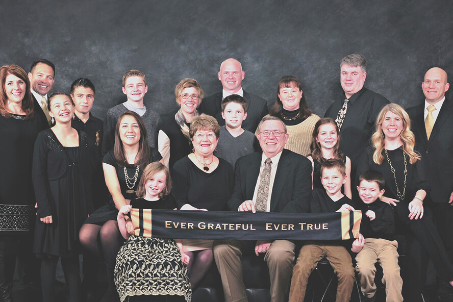 Vic Lechtenberg and his wife, Grayce, pose with their extended family. Lechtenberg and his wife are holding a banner that reads “Ever Grateful. Ever True.”