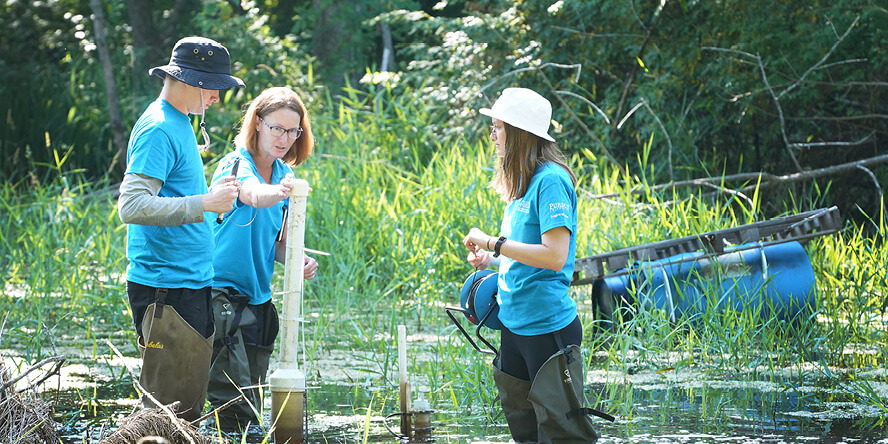 Laura Bowling in pond with students.