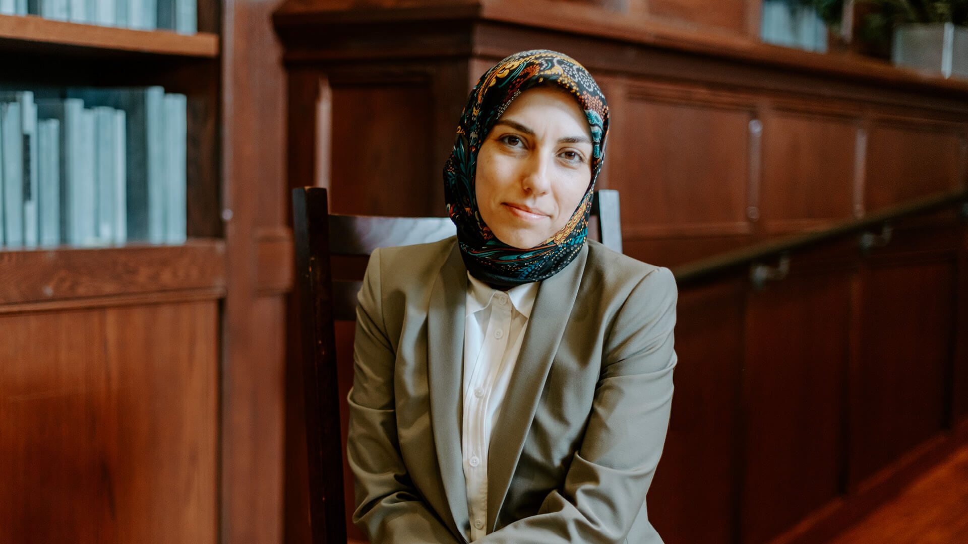 Zahra Tehrani in front of bookshelf.