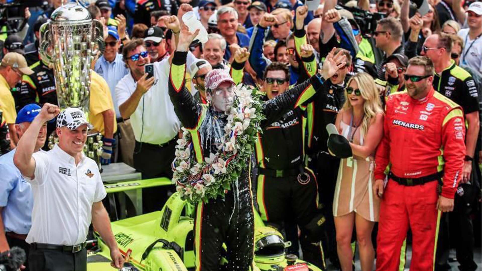 Purdue graduate Andrew Kuehnert, bottom left, presented driver Simon Pagenaud and his team with their milk trophies to celebrate winning the 2019 Indianapolis 500.