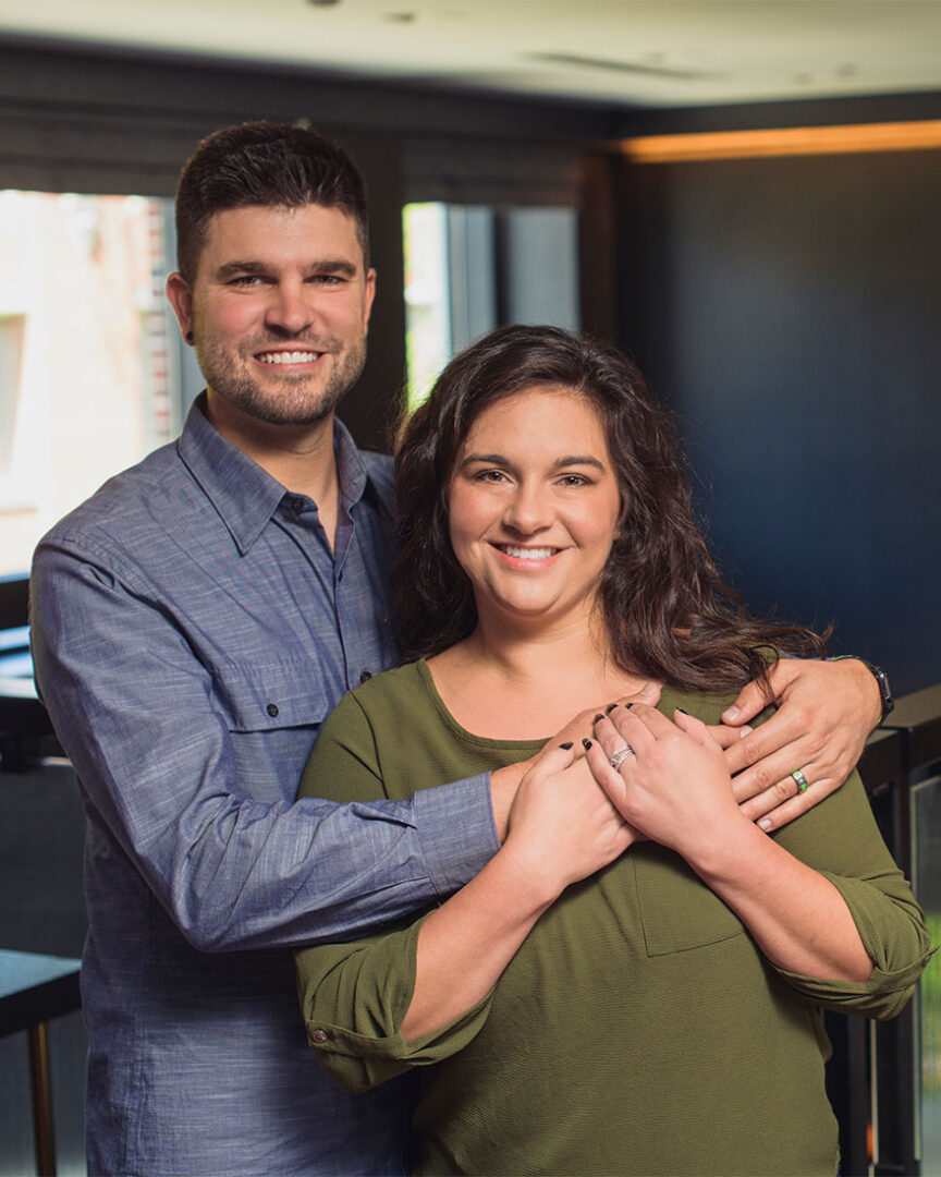 Keegan has his arms around Lauren as they smile at the camera.