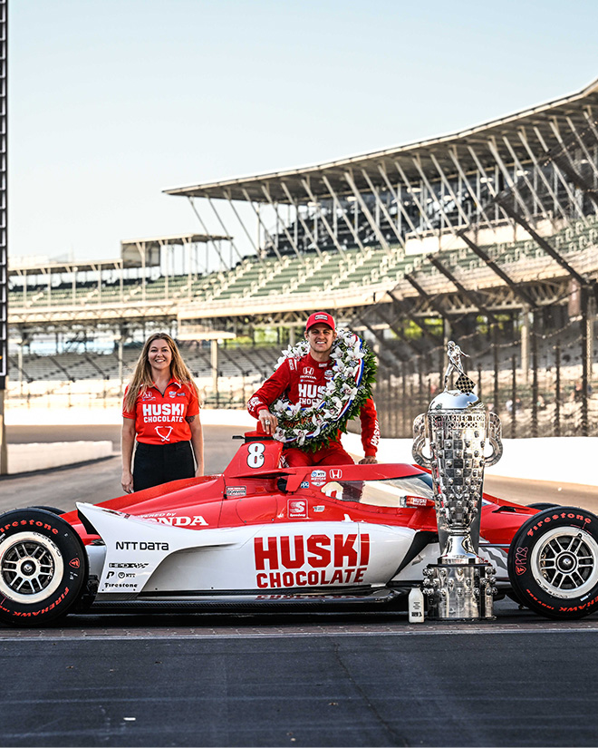 Hutton stands next to Marcus Ericsson, and behind his winning No. 8 Honda, after the Indy 500.