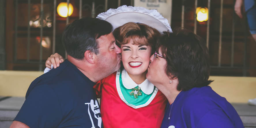 Bruso is in costume for the Christmas Trolley Show, as both her parents give her a kiss on the cheek