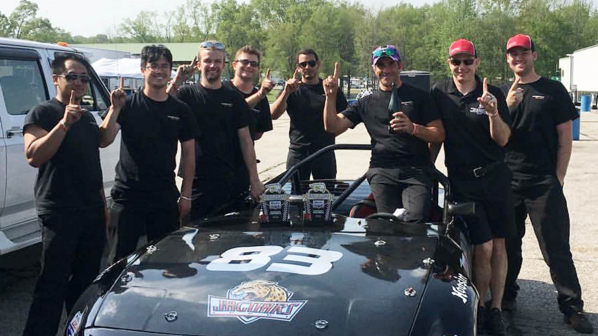 Students involved in the motorsports engineering program standing by a car.