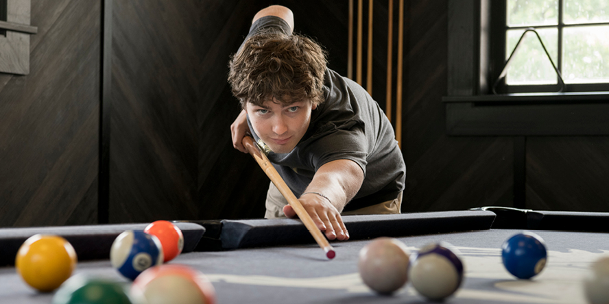 Kinder shooting pool at the Beta Theta Pi house.