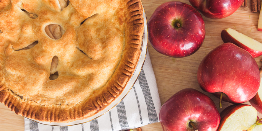 An overhead view of apple varieties and an apple pie.