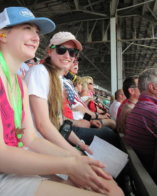 Sisters Annie and Lizzie Todd watch the Indianapolis 500 from their family’s seats at the Indianapolis Motor Speedway.