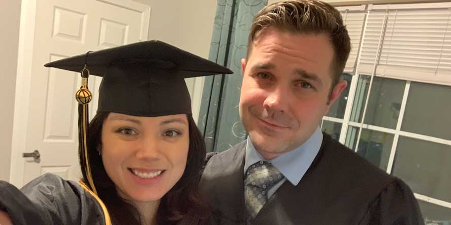 A selfie taken by Nelly, dressed in a cap and gown with a Purdue Global globe on her tassel, with her husband who is also dressed in a graduation gown. 