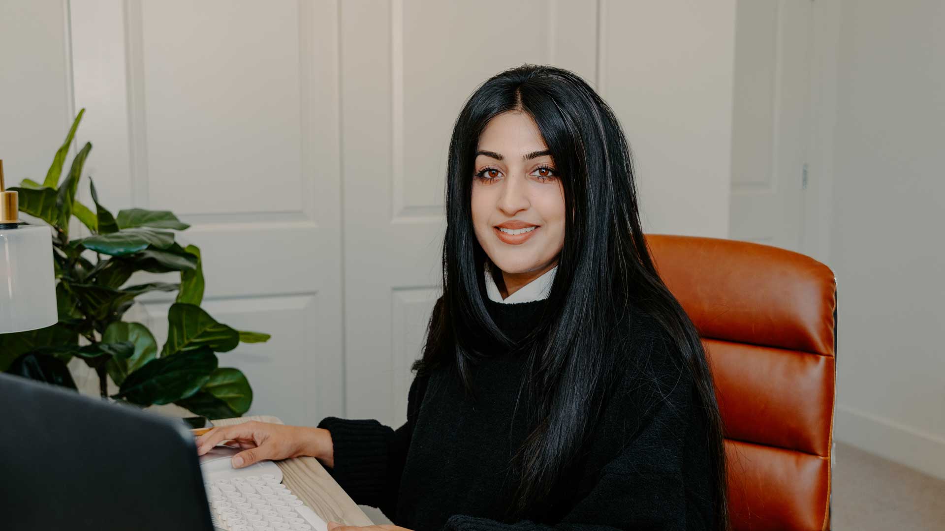 Rana sits at the desk in her home office