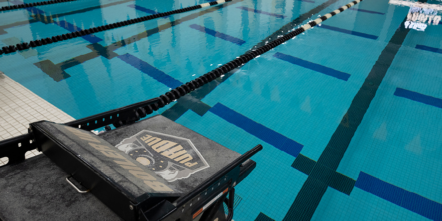 Swimming starting blocks with Purdue branding on them and pool in the background 