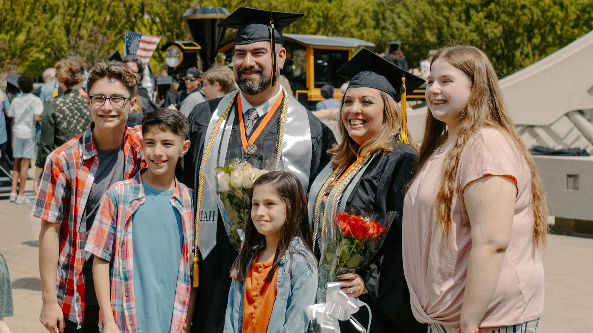 The Ortizes, with a few of their children, smile together after their commencement ceremony, by the Engineering Fountain.