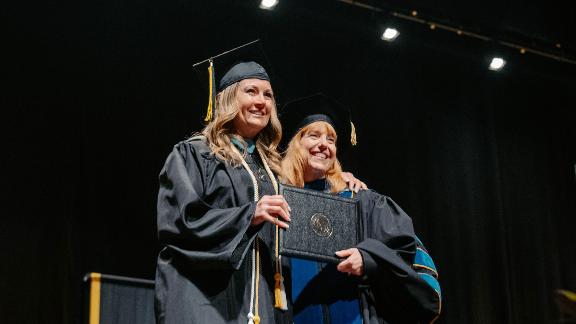 Patti accepts her diploma and poses with her dean for a picture.