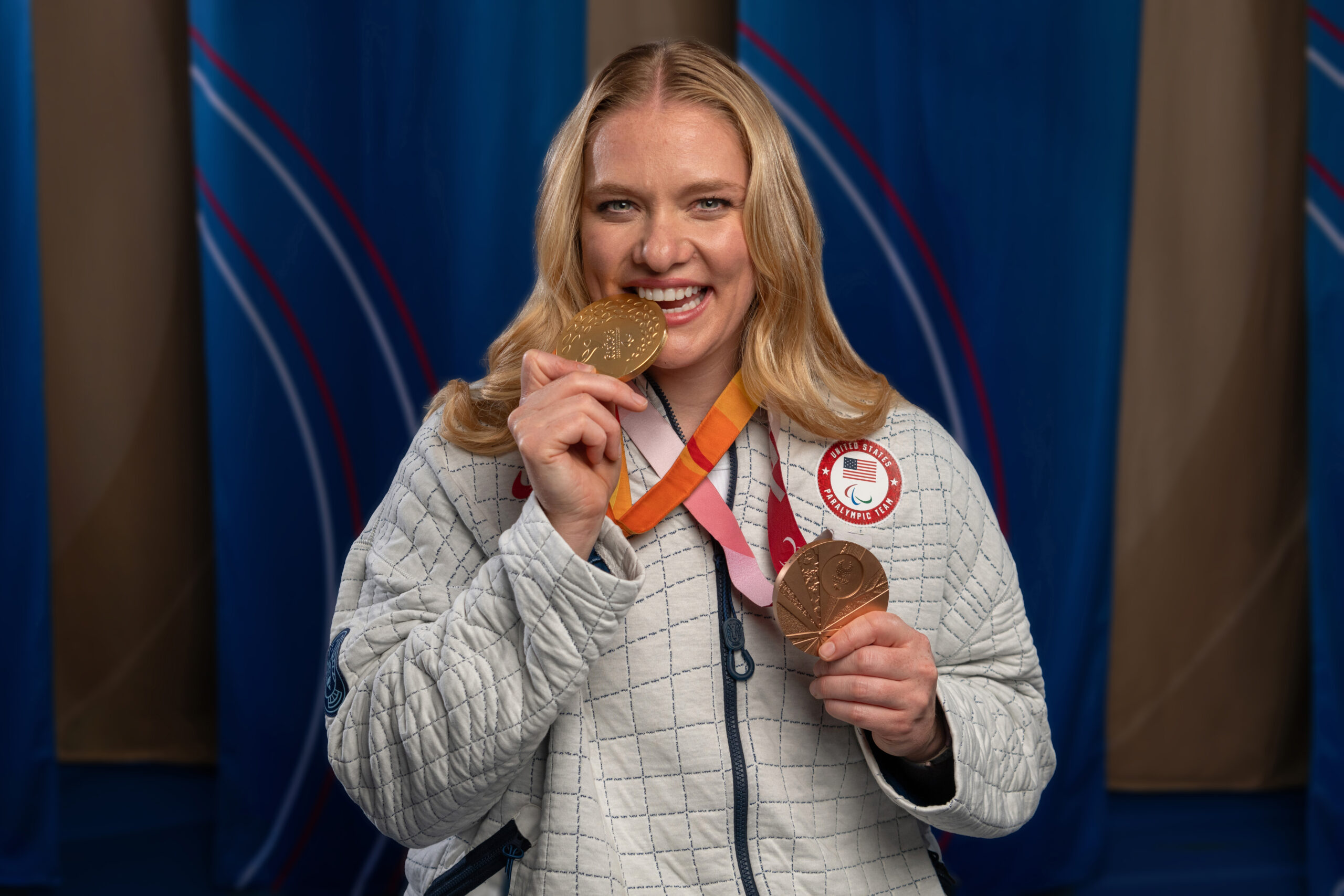 Hollermann wears both her Paralympic medals and bites the gold one.